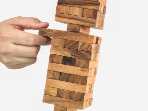 A man moving a jenga tower representing organising a stag party