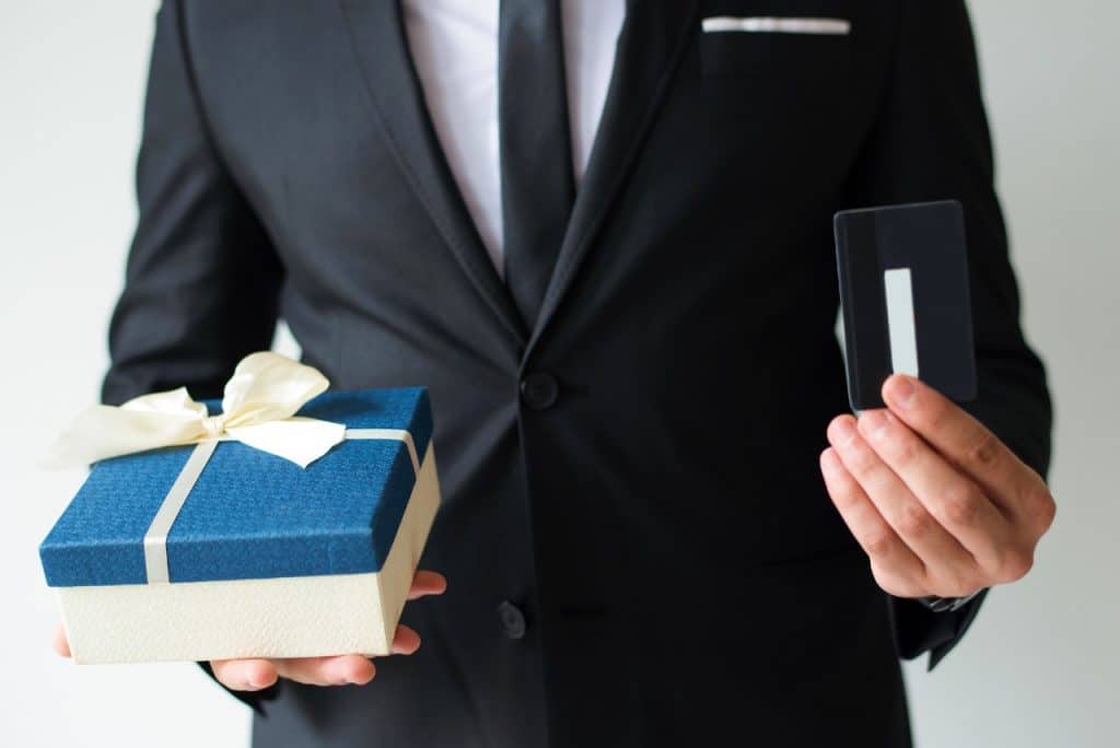 A best man holding a best man gifts to the groom in his hand