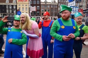 A stag party group wearing mario brothers stag do costumes on a street abroad in Europe